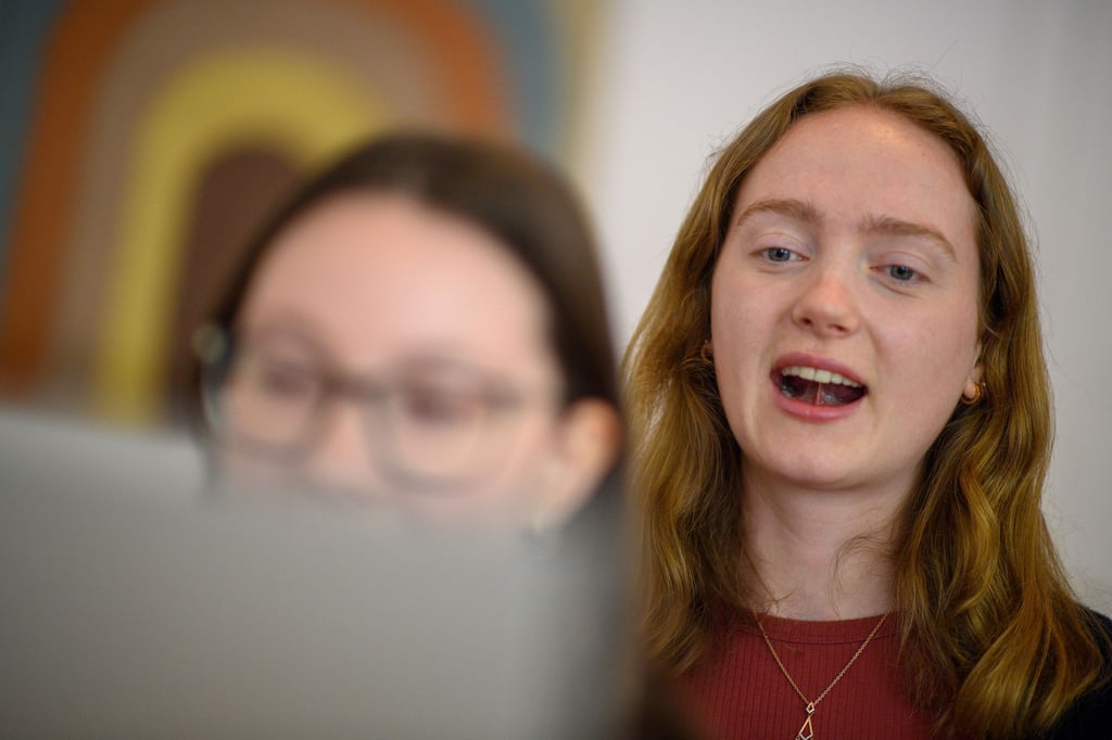 Logopädin Selma Klee (r) demonstriert mithilfe eines Spiegels eine Übung, bei der es um das Ansaugen der Zunge geht.