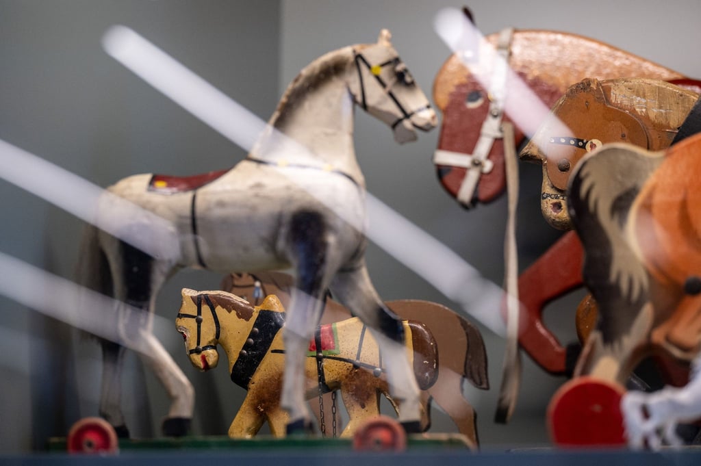 Historisches Kinderspielzeug steht in einem Archivschrank im Schaudepot des Kinderwagenmuseums.