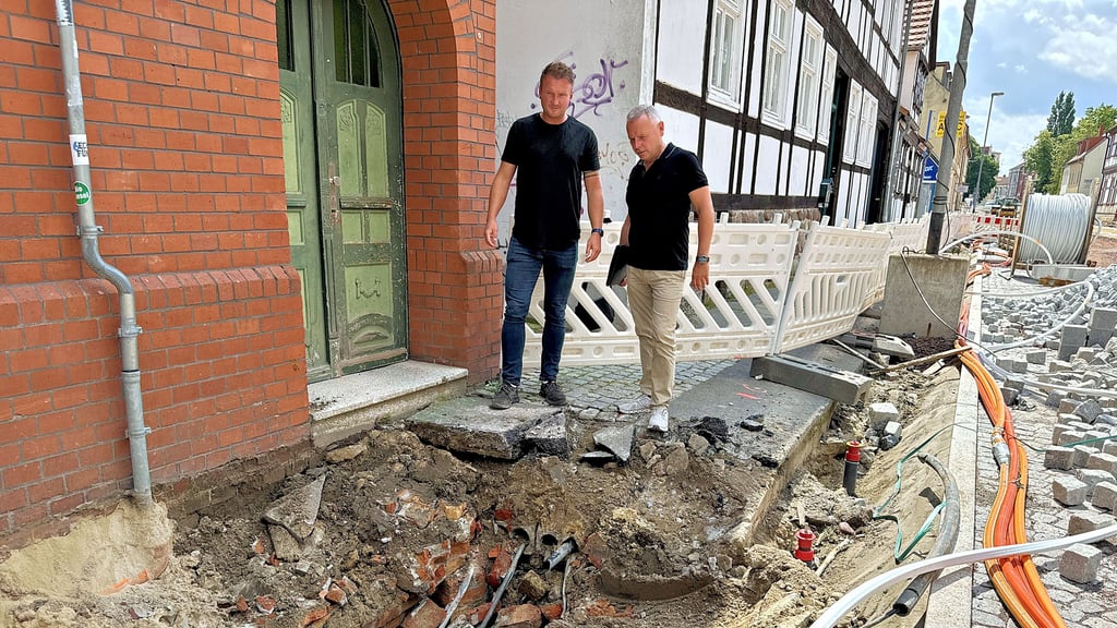 Baustelle Hallstraße Stendal: Firmenchef Christian Punzel (rechts) und sein Bauleiter Tomasz Hampel betrachten einen der Schächte, in dem viele Leitungen verlegt sind.