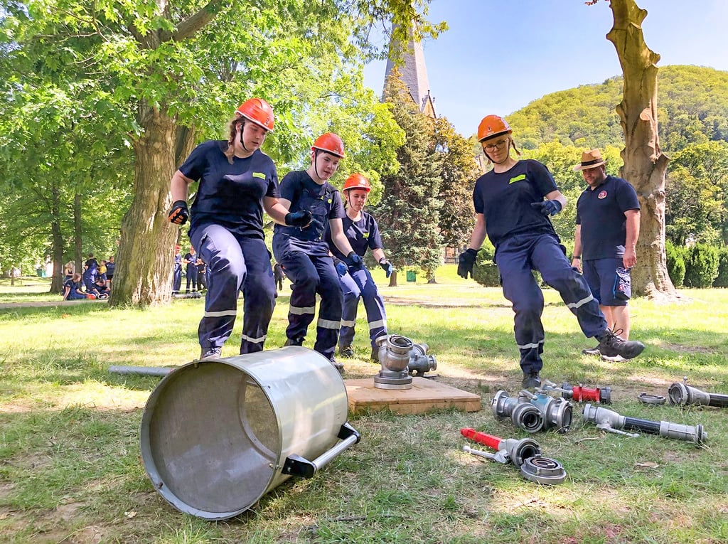 Ein Team der Jugendfeuerwehr Thale startet zum Bau einer Pyramide aus Ausrüstungsteilen.