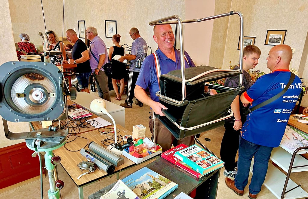 17 Stühle und einen großen Tisch hat sich Axel Krause (Mitte) beim Flohmarkt im Kurhaus Bernburg gesichert.