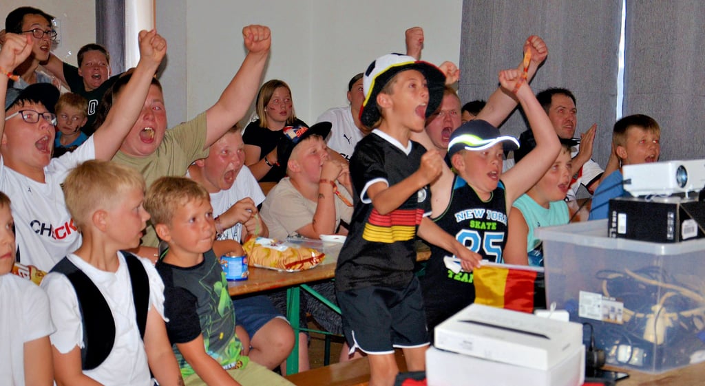 Fußballfans im Zeltlager der Kreisjugendfeuerwehr in Güsten bejubeln das erste Tor beim EM-Viertelfinale Deutschland-Dänemark.