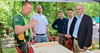 Holzkünstler Andreas Uhde aus Remkersleben (links) erklärt beim diesjährigen Familientag im Hohen Holz sein Handwerk. Unter den interessierten Besuchern war auch Landrat Martin Stichnoth (Zweiter von links).