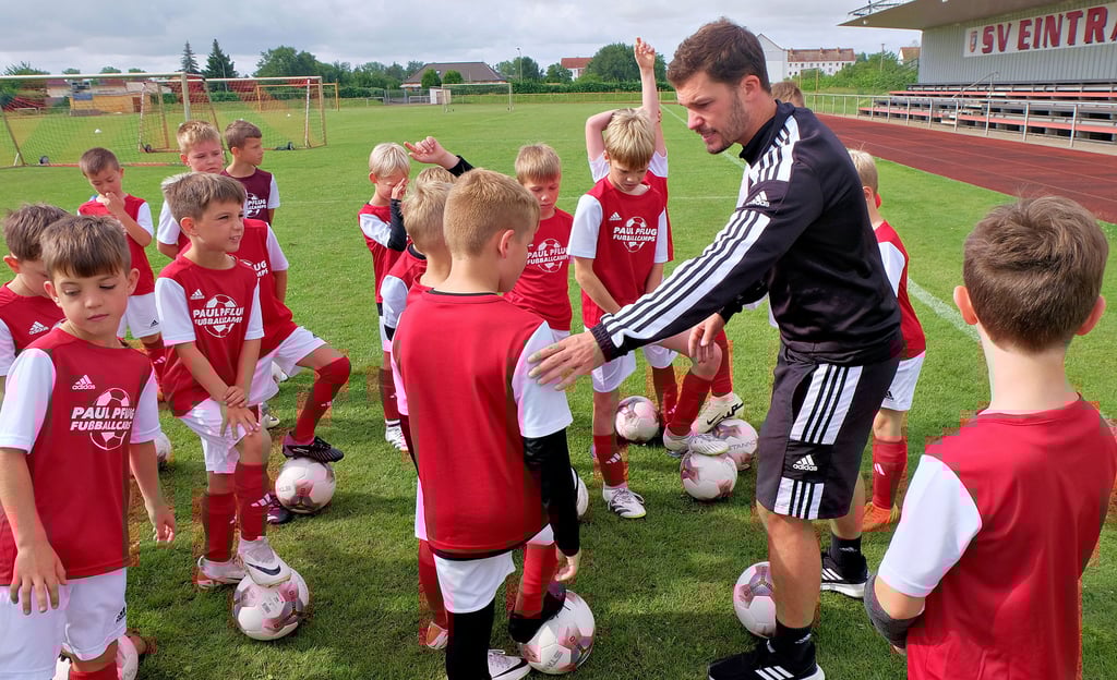 Cheftrainer Paul Pflug erklärt den Kindern in Elster, wie ein Übersteiger, also ein Täuschungsmanöver, bestens funktioniert.