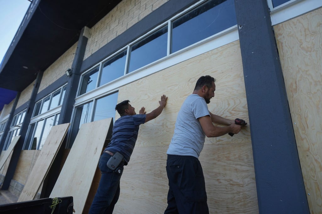 Mitarbeiter eines Möbelhauses in Mexiko verschalen die Fenster zum Schutz vor dem erwarteten Hurrikan „Beryl“.
