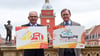 Gotha bereitet sich auf den Thüringentag 2025 vor. Ministerpräsident Bodo Ramelow (r.) und OB Knut Kreuch (SPD) mit den Logos von Landesfest und Stadtjubiläum vor dem Historischen Rathaus.