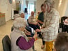 Kathleen Topfmaier und Anje Lellau spielen mit den Senioren ein Kartenspiel beider täglichen Beschäftigungsrunde. 