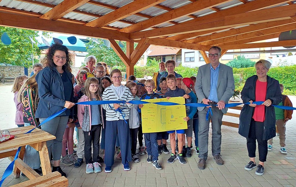 Kinder durchtrennen mit Oberbürgermeisterin Christina Buchheim (re.), Katrin Bogda und Christian Wallschläger das blaue Band vor dem Brunnen.