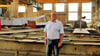 Prokurist Ralf Luther steht in einer Produktionshalle der Stahlbau Magdeburg – im Hintergrund ein Brückenteil.