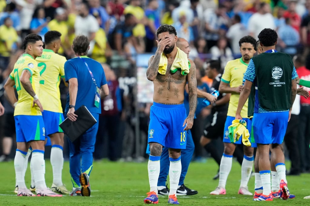 Trauer bei den brasilianischen Spielern: Douglas Luiz hält sich die Hand vor das Gesicht.