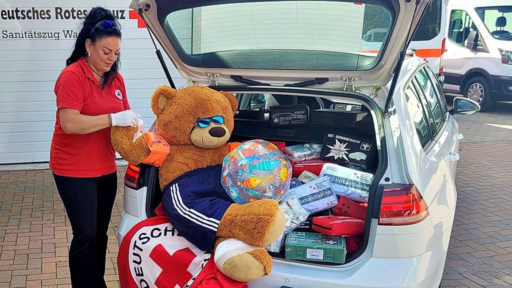 Monique Wrüske, Ausbilderin für Erste Hilfe im DRK Wanzleben, mit den eingetauschten Verbandskästen und dem Vorführteddy Bruno.