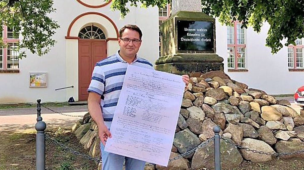 Christoph Schulze zeigt das sanierte Denkmal samt der Urkunde von der Grundsteinlegung.