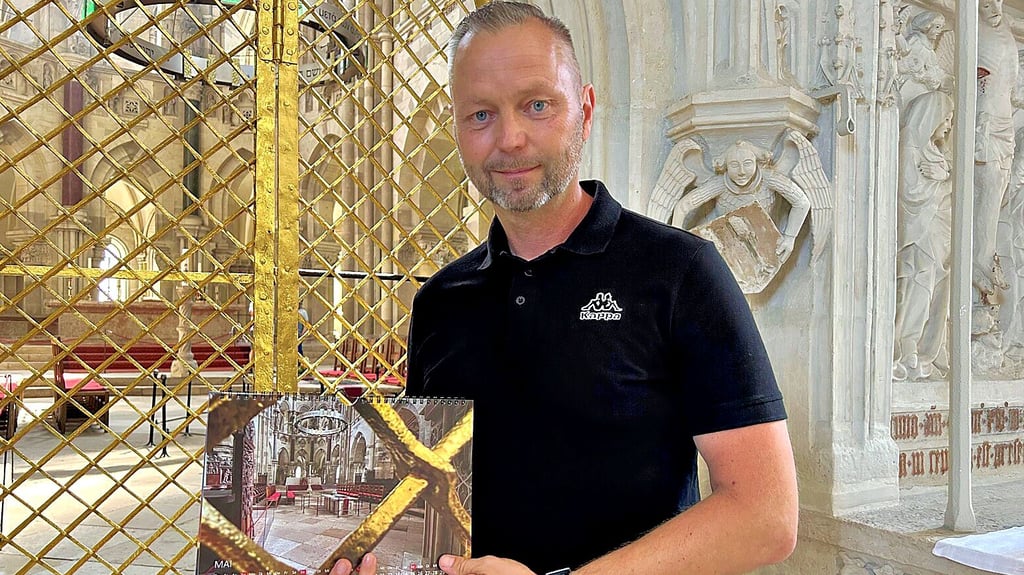 Jörg Porrmann zeigt im Dom den Kalender mit seinem Sieger-Foto.