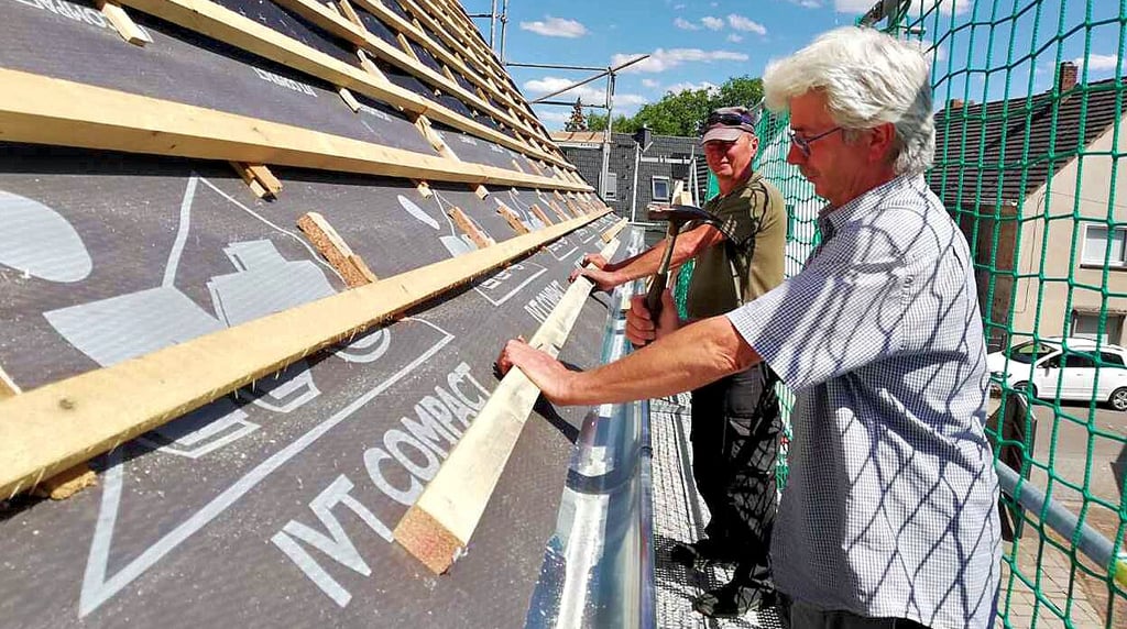 Dachdecker Wolfgang Pusch (vorn) deckt in Staschwitz ein Dach neu ein. Hier weht bei 30 Grad ein laues Lüftchen.