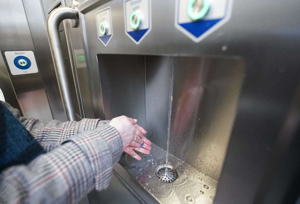 Eine Frau wäscht sich in einer öffentlichen Toilette die Hände. In Sachsen-Anhalt gibt es nur an wenigen Bahnhöfen und Haltepunkten öffentliche Toiletten. (Archivbild)