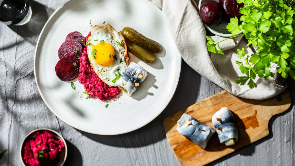Labskaus: Das traditionelle Seemannsgericht aus Kartoffeln, Corned Beef, Roter Bete und Fisch, wird durch Rollmöpse, Gurken und Spiegelei ergänzt, zum Geschmackserlebnis.