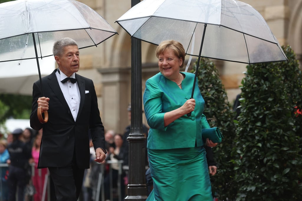 Im letzten Jahr mussten sich Angela Merkel und Ehemann Joachim Sauer auf den Weg ins Bayreuther Festspielhaus mit Regenschirmen schützen. (Archivfoto)
