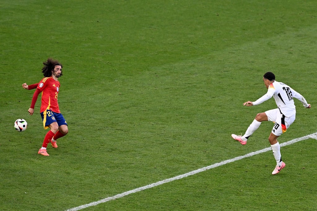 Marc Cucurella (l) bekommt den Schuss von Jamal Musiala an die Hand.