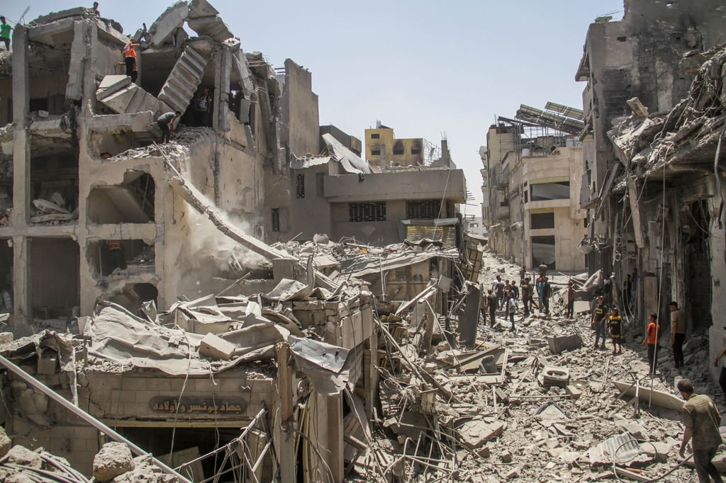 In der Stadt Gaza stehen Palästinenser inmitten zerstörter Gebäude