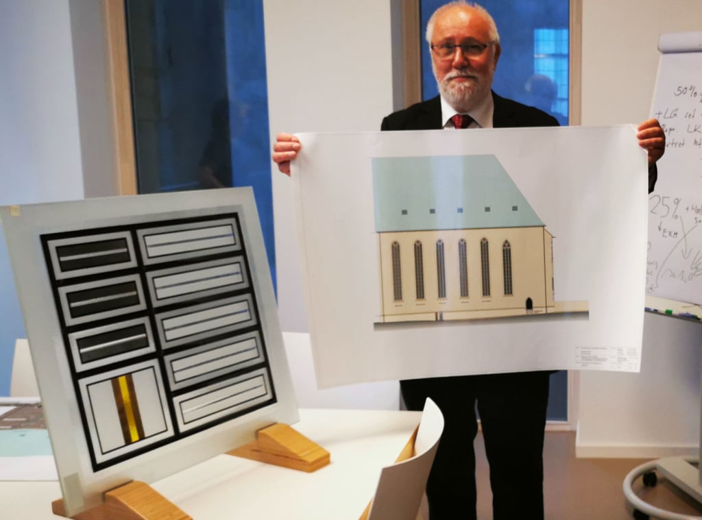Thomas Böttcher zeigt einen Entwurf der Fassadensanierung. Links im Bild: Ein Element der neuen Kunstfenster, die bis zum Jahresende in die Westfront der Wallonerkirche eingebaut werden sollen.