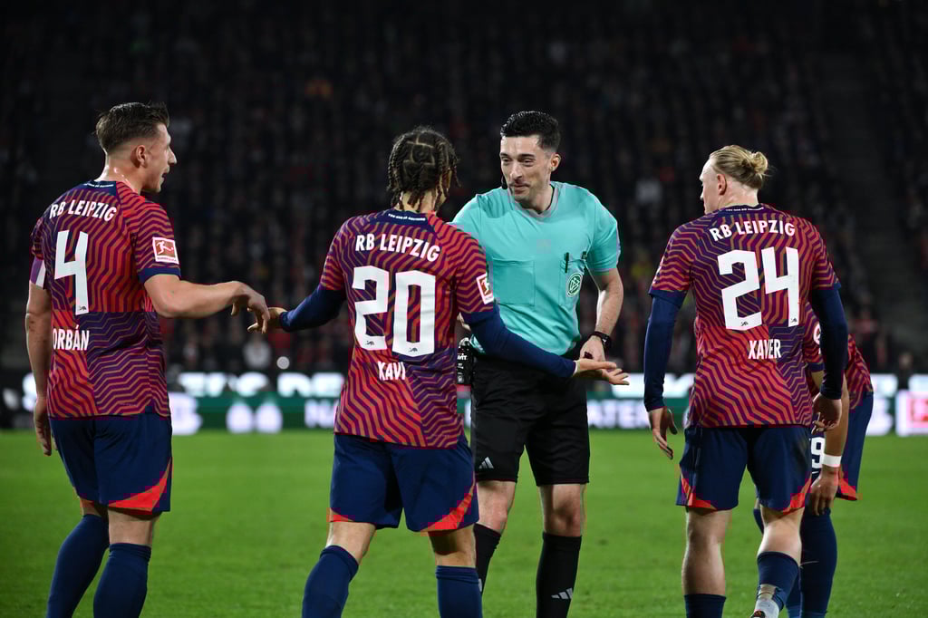Die RB-Profis Orban, Xavi und Schlager (v.l.) bedrängen Schiedsrichter Florian Badstubner