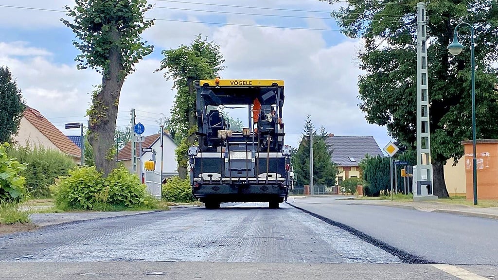Die Aspahltmaschine fährt wieder zurück zum Anfang, um dann auch die zweite Spur mit neuer Schwarzdecke zu belegen.