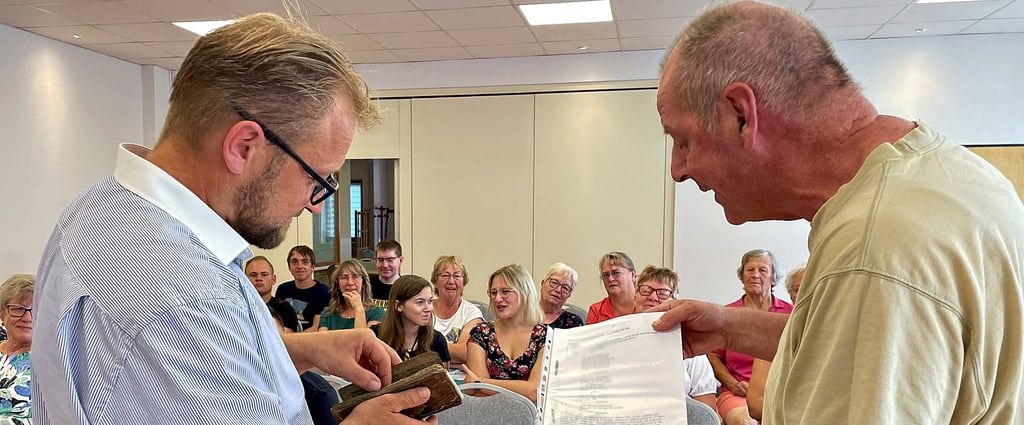 Michael Pieper (r.) überreicht Daniel Schünicke zur Amtseinführung ein historisches Büchlein samt transkribiertem Text.
