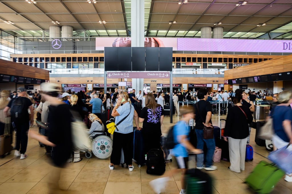 In der Haupthalle des BER bilden sich lange Schlangen vor den Check-in-Schaltern.
