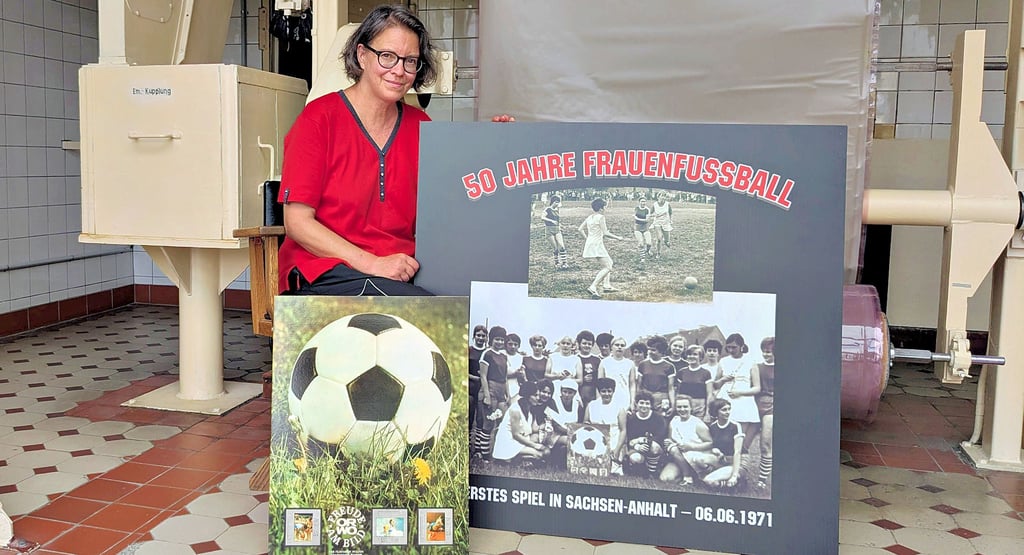 Andrea Mähl vom Industrie- und Filmmuseum zeigt das Plastikposter und das Fußballmotiv, das als Plakat auf dem Poster ist.