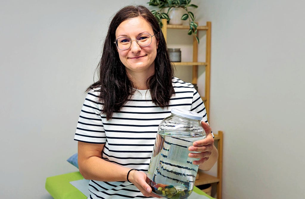 Melanie Scheibe mit einem Glas, in dem sich ein Blutegel befindet.