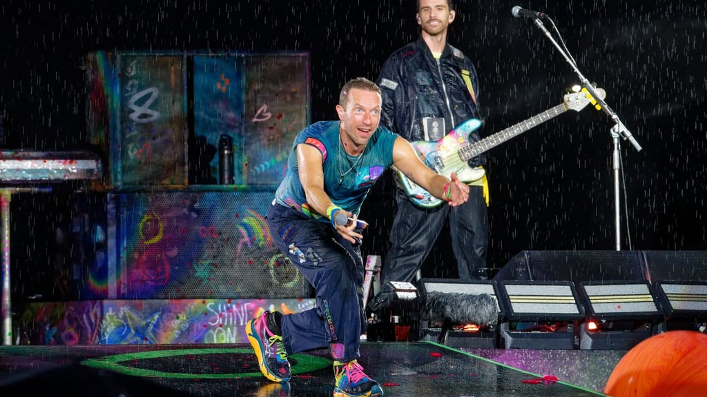 Bei starkem Regen beginnt Coldplay die Performance in Düsseldorf.