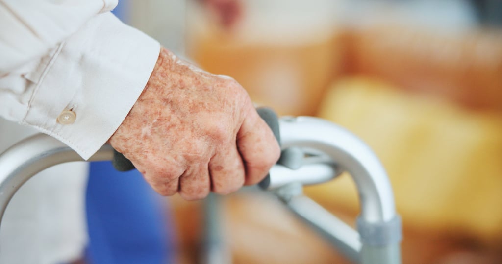 Die Hand eines Senioren am Rollator in einem Pflegeheim: In Magdeburg hoffen pflegende Angehörige auf einen Pflegenotruf.