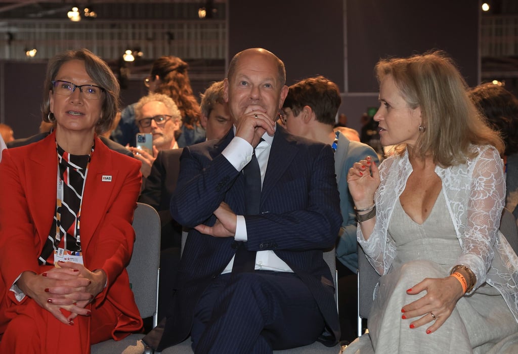 Bundeskanzler Olaf Scholz (SPD, M), sitzt bei der Eröffnung der 25. Welt-Aids-Konferenz zwischen Birgit Poniatowski (l), Geschäftsführerin der International AIDS Society (IAS) und Sharon Lewin (r), Präsidentin der International AIDS Society.