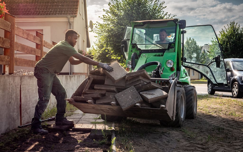 Mitarbeiter der Firma Ferchland entfernen die alten DDR-Gehwegplatten in der Menzer Dorfstraße.