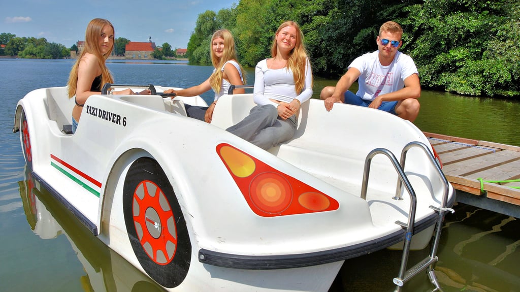 Bella (v.l.), Leni und Lina fahren mit dem Tret-Boot-Taxi über den Flechtinger Schloss-See. Alexander Philipp hilft den Mädchen beim Ablegen.