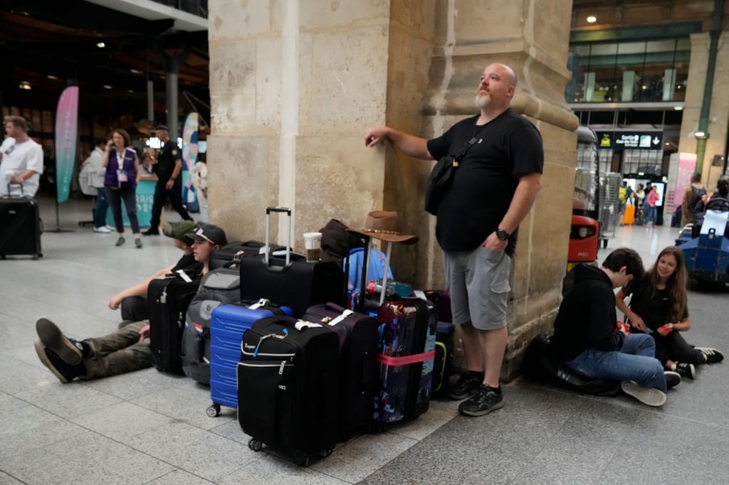 Reisende sitzen wegen der Brandanschläge an einem Bahnhof in Paris fest.