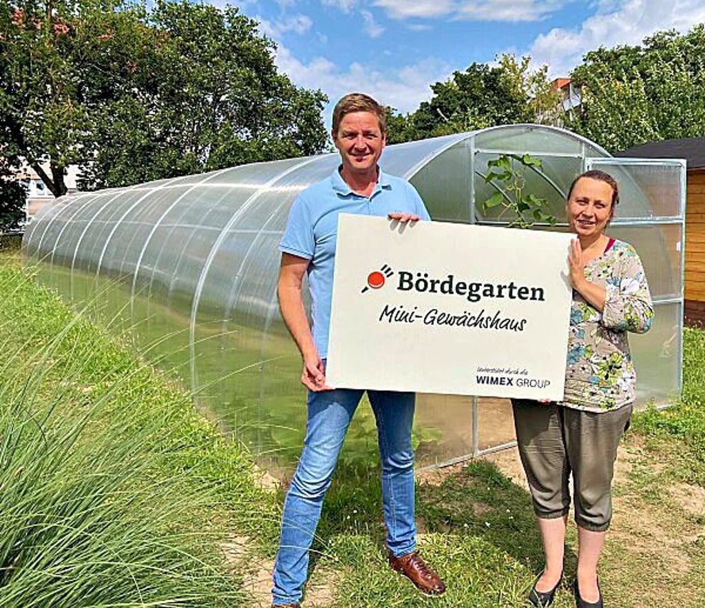 Nicole Erben vom Verein „Grüner Daumen“ und Michael Tepfer von Wimex vor dem Gewächshaus