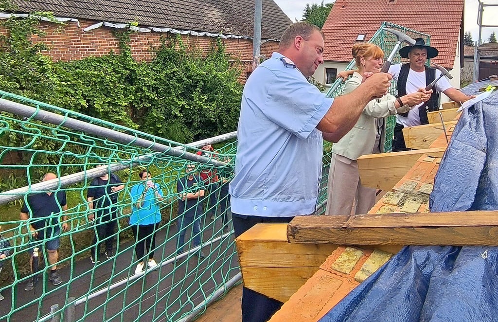 Unter den neugierigen Blicken der zahlreichen Schaulustigen und Zimmerermeister Jörg Hoffmann zeigte sich Bürgermeisterin Annegret Schwarz beim Einschlagen des letzten Nagels treffsicherer als Ortswehrleiter Alexander Wunderlich und ersparte sich Bier zu sponsern.