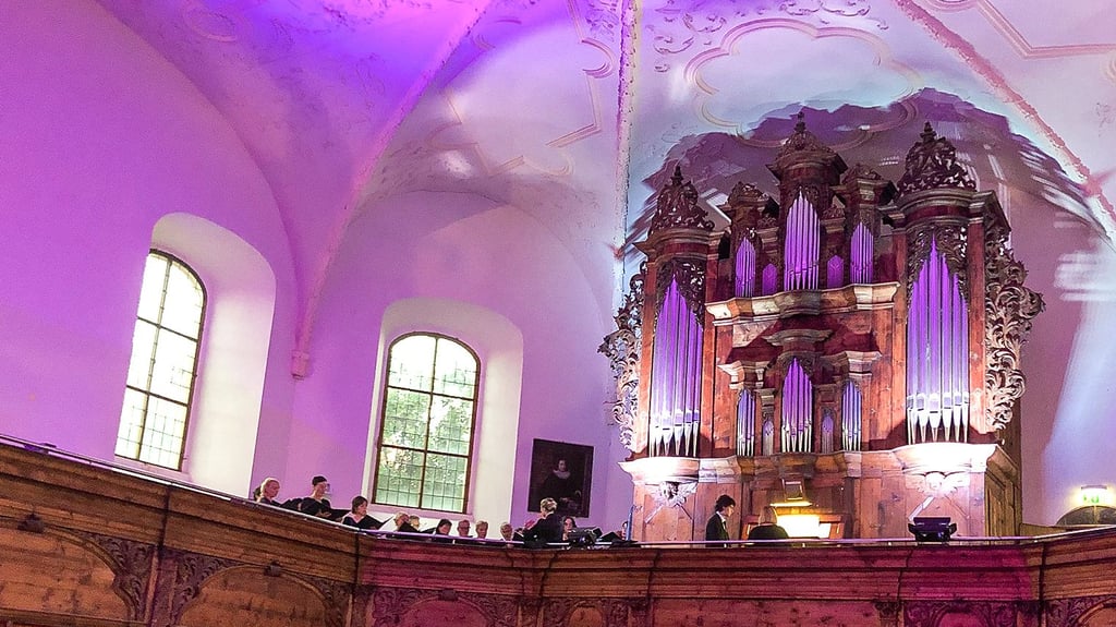 Sein Konzert begann der Chor auf der Empore neben der ebenfalls beleuchteten Orgel.