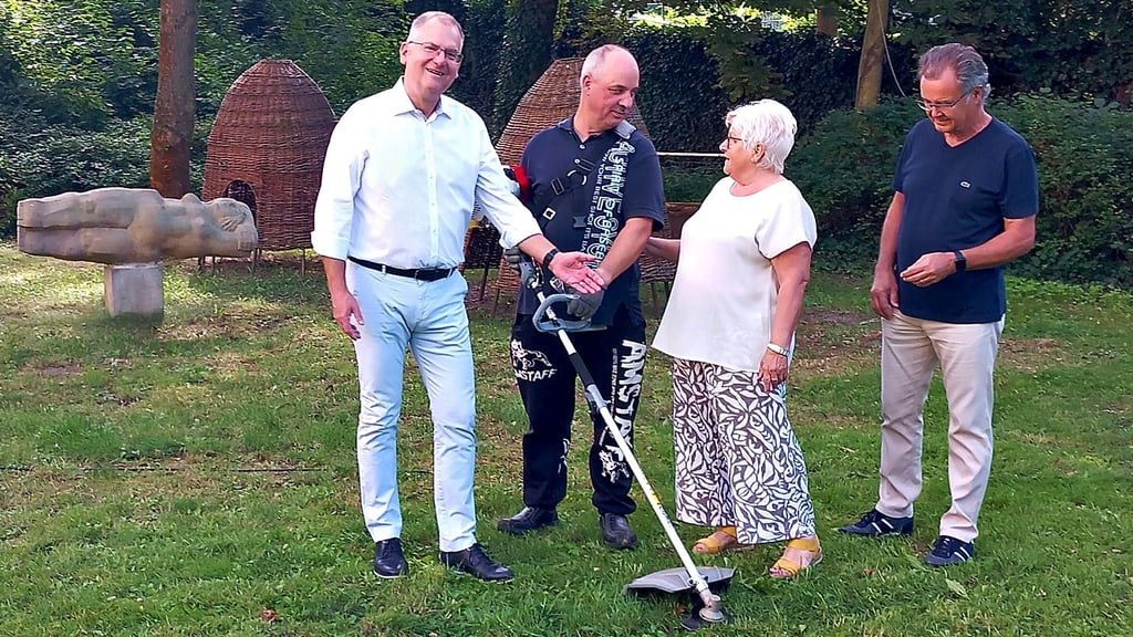 Andreas Kersten (v.l.), Ingo Gietz, Christine Laqua und Wolfgang Werner mit dem Freischneider im Park.