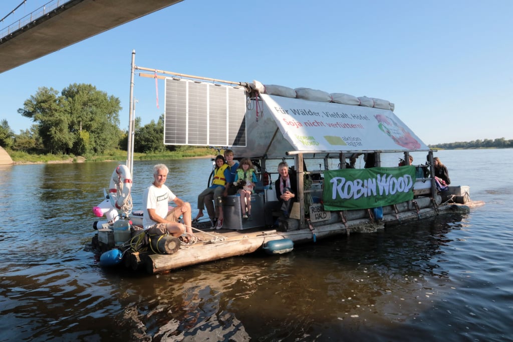 „Für Wälder, Vielfalt, Höfe – Soja nicht verfüttern“ steht auf dem Floß, das hier unterm Herrenkrugsteg auf der Elbe schwimmt.
