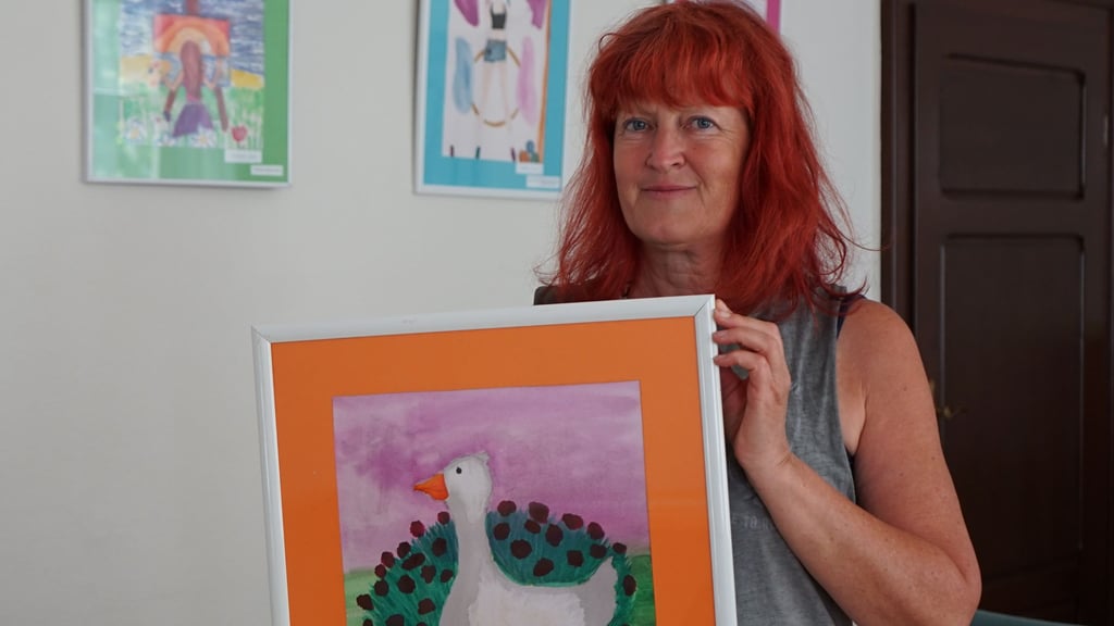 Heike Wolter zeigt Bilder der Ausstellung über Wolmirstedter Vereine.