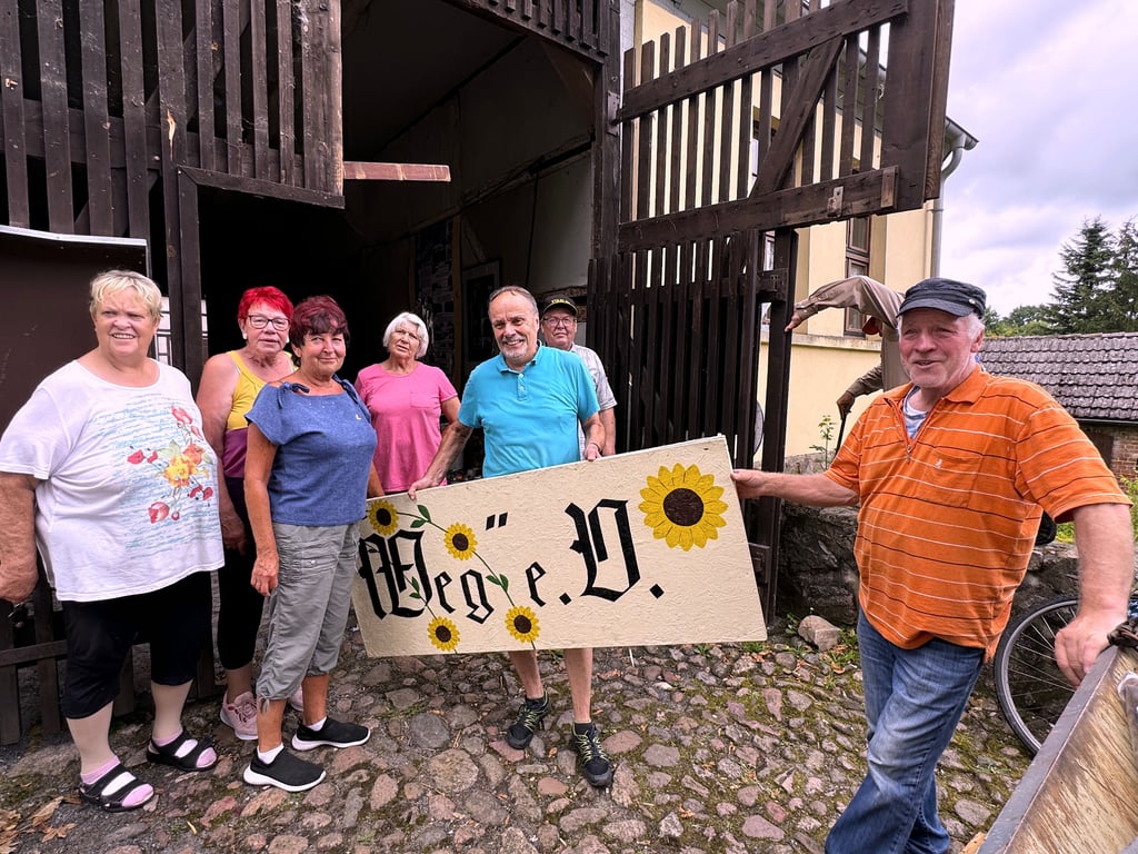Der e.V ist dann mal weg von der Burg: Vereinsmitglieder des Loburger Weges  mit einem Teil des Schildes, das über dem Burgeingang hing.