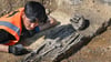 Ausgrabungen im Saalekreis bei Wettin-Löbejün: Grabungsarbeiter Kazim Bakhtivari legt die Bestattung eines kranken Kindes mit einem sogenannten Wasserkopf frei.