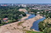 Dieses Luftbild zeigt eindrucksvoll die zunehmende Verlandung der Alten Elbe in Magdeburg. Das übrig gebliebene Wasser schlängelt sich an riesigen Sedimentflächen vorbei. 