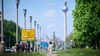 Spaziergänger gehen unter einem blauen Himmel über die Frankfurter Allee in Berlin. (Symbolbild)