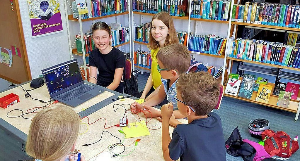 Kinder programmieren ein Computerspiel mit der Makey Makey-Platine.