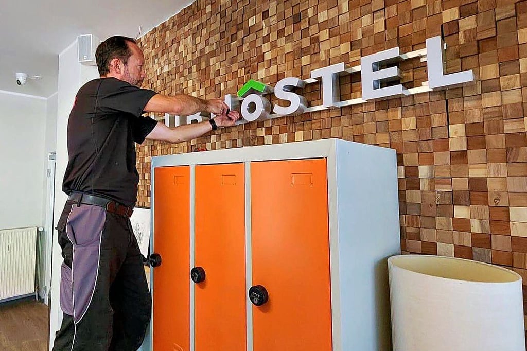 Die alten Schilder des Clubhostels in Dessau werden demontiert. Künftig empfängt hier das "Wandery Hostel".