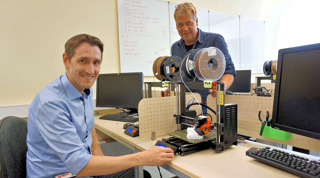 Dr. Marco Götze und Laboringenieur Ronny Kunow im 3D-Druck-Labor. Solche Drucker finden sich heutzutage oft auch bei Privatanwendern daheim. Hier wird aber gerade der Prototyp eines Automodells gedruckt. Das dauert etwa einen Tag lang.