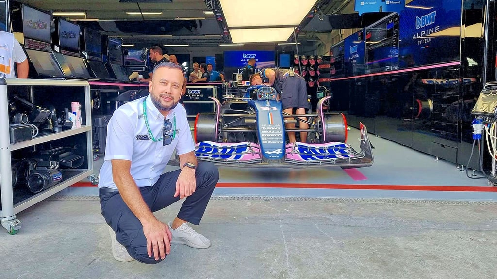 Ravshan Makhumudov in der Boxengasse, dahinter der Flitzer des Franzosen Esteban Ocon.